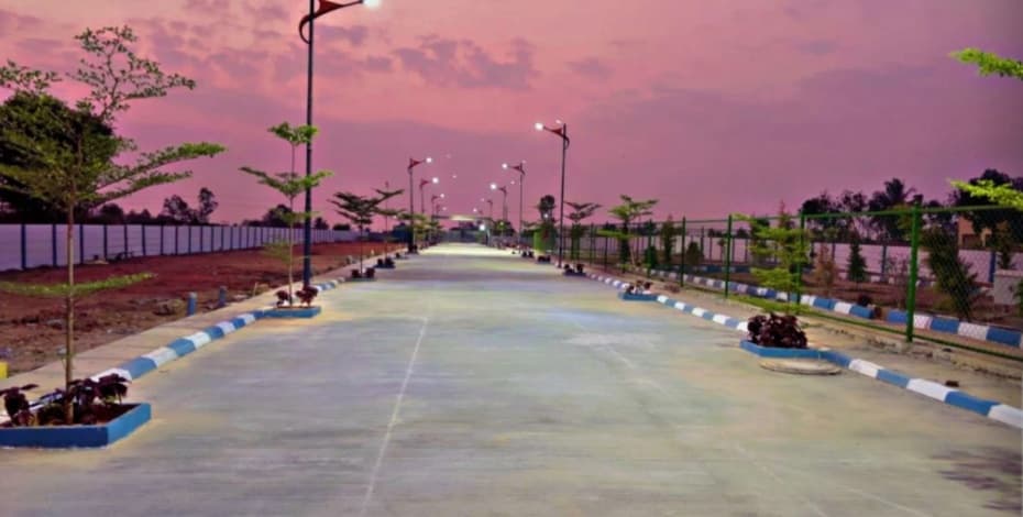 Chamundeshwari Residency illuminated concrete avenue during evening with street lights