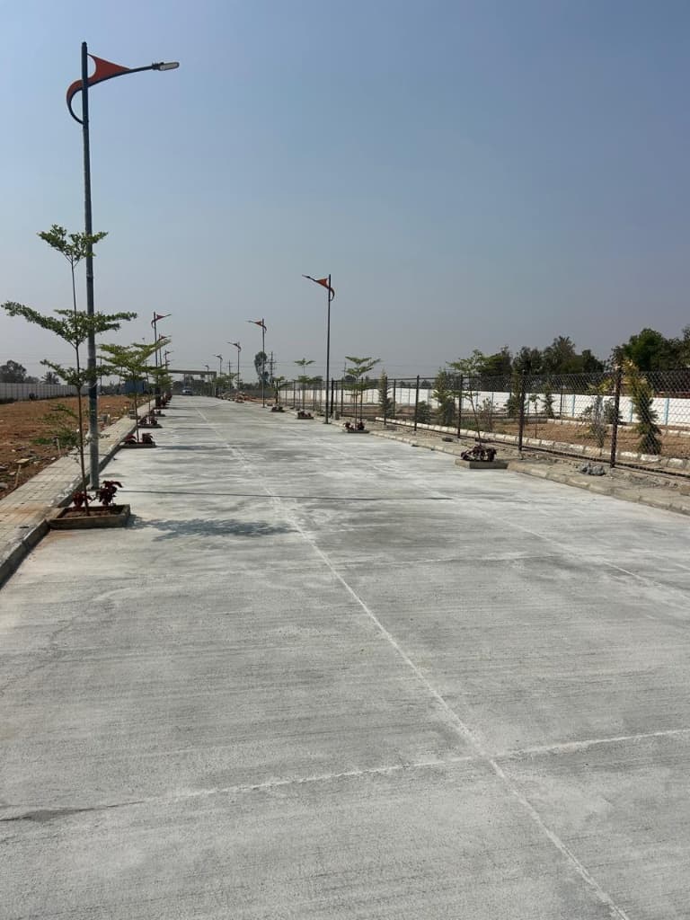 Chamundeshwari Residency paved concrete avenue with street lights and fencing